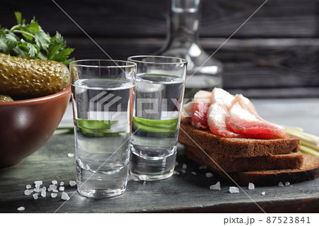 Cold Russian vodka with snacks on wooden table Cold Russian vodka with snacks on wooden table 87523841