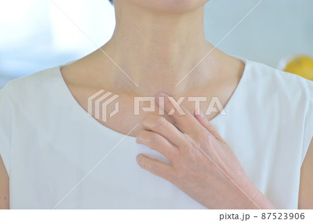 デコルテを手で触る女性 87523906