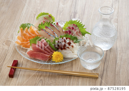 ガラスの皿に盛られた刺し身と日本酒 87528195