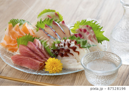 ガラスの皿に盛られた刺し身と日本酒 87528196