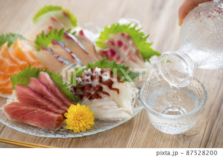 ガラスの皿に盛られた刺し身と日本酒 87528200