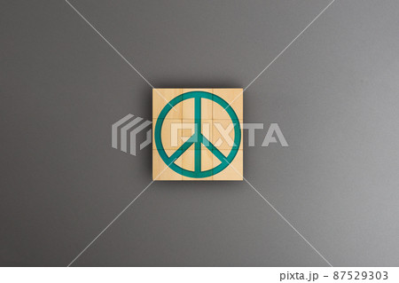 Symbol peace on wooden block over gray background, War, Boycott, Nuclear war, Hope, Economy Symbol peace on wooden block over gray background, War, Boycott, Nuclear war, Hope, Economy 87529303