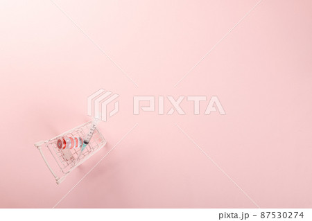 Shopping cart with vaccine vials bottles and syringes for vaccination against coronavirus 87530274