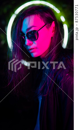 Portrait of asian man wearing sunglasses in neon light.  87530771