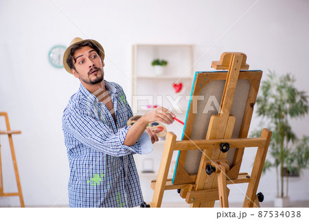 Young man enjoying painting at the studio Young man enjoying painting at the studio 87534038