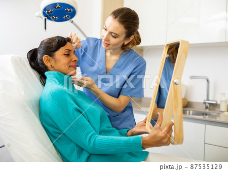 Woman having consultation at aesthetic medicine clinic 87535129