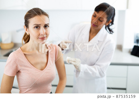 Woman doctor vaccinating patient Woman doctor vaccinating patient 87535159