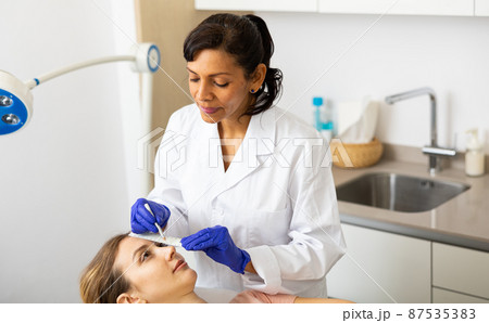 Beautician drawing correction lines on woman face Beautician drawing correction lines on woman face 87535383