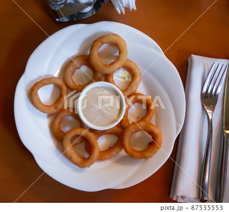 Crispy fried onion rings served with sauce 87535553