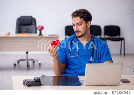 Young male doctor cardiologist working in the clinic 87536045