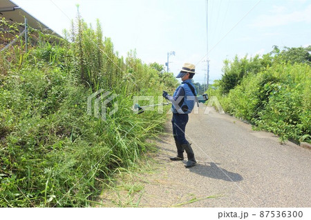 道路沿いの除草作業　草刈りをする男性　 87536300