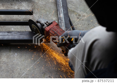 Close up, A man working with angle grinder. Iron gate repair Close up, A man working with angle grinder. Iron gate repair 87537211