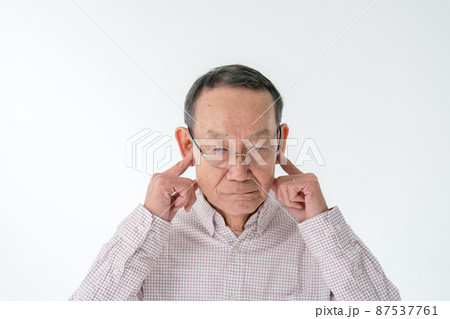 耳を塞ぐシニア男性 87537761