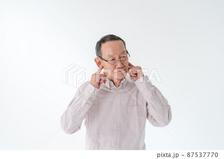 耳を塞ぐシニア男性 87537770