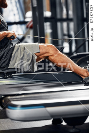 Training legs in the simulator, the athlete works with his legs on the simulator, working out the muscles on the legs Training legs in the simulator, the athlete works with his legs on the simulator, working out the muscles on the legs 87537857