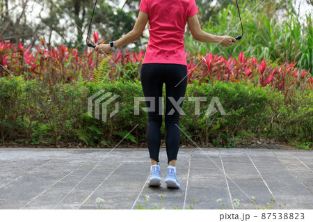 Asian woman skipping rope in park 87538823