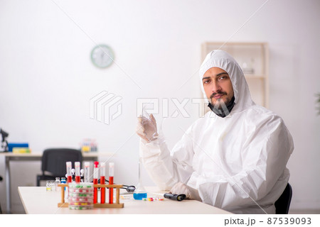 Young male chemist in drugs synthesis concept 87539093