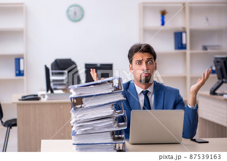 Young businessman employee unhappy with excessive work in the of 87539163