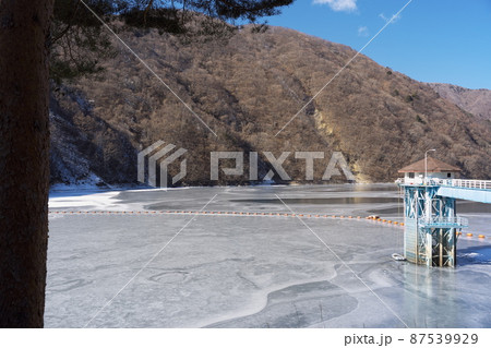 冬のダム湖が凍る幻想的な風景 87539929