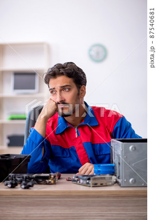 Young male repairman repairing computer 87540681