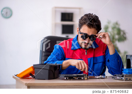 Young male repairman repairing computer 87540682