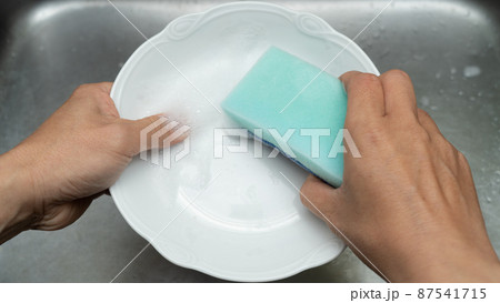 洗剤をつけたスポンジで食器を洗う 87541715