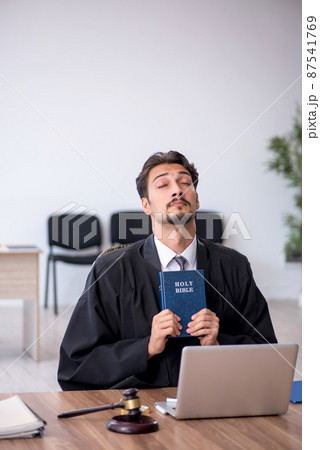 Young male judge taking oath on holly bible Young male judge taking oath on holly bible 87541769