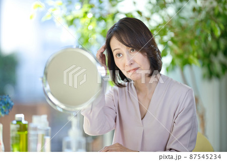 髪の毛を気にするシニアの女性 87545234