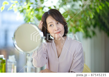 髪の毛を気にするシニアの女性 髪の毛を気にするシニアの女性 87545235