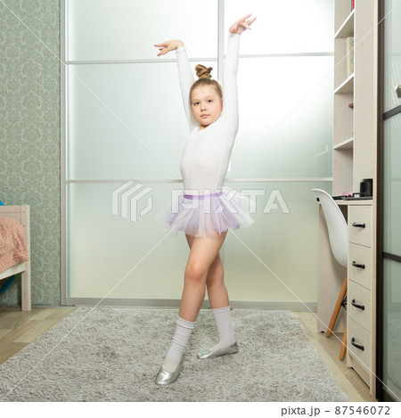 A little ballerina in a white swimsuit dances at home, learns to dance remotely. Dance lessons at home A little ballerina in a white swimsuit dances at home, learns to dance remotely. Dance lessons at home 87546072