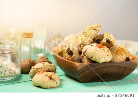 Freshly baked soft oatmeal cookies with raisins, candied fruit, flax and sesame seeds and walnuts close-up in a heart-shaped wooden plate 87546091