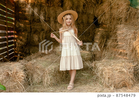 Romantic tween girl standing on hayloft during summer rural vacation 87548479