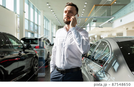 businessman chooses a new car in a premium car dealership businessman chooses a new car in a premium car dealership 87548650