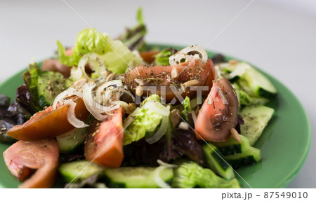 vegetable salad of greens, tomatoes and cucumbers on a green plate vegetable salad of greens, tomatoes and cucumbers on a green plate 87549010