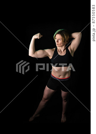 Low key full length portrait of a 35 year old white woman in fitness clothes 87550583