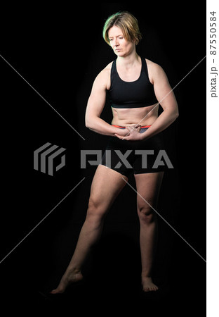 Low key full length portrait of a 35 year old white woman in fitness clothes 87550584