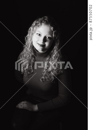 Studio Portrait of a 21 year old white blonde woman with curling hair Studio Portrait of a 21 year old white blonde woman with curling hair 87550702