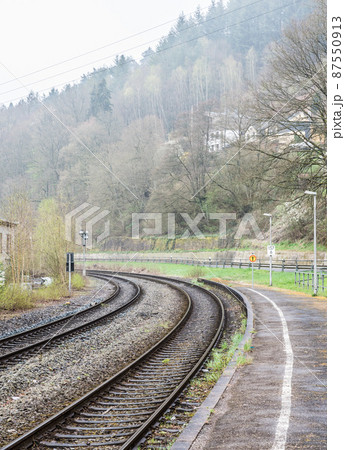 Kordel, Rhineland-Palatinate - Germany -Double bending railwaytrack in the foggy nature landscape along the Kyll creek valley Kordel, Rhineland-Palatinate - Germany -Double bending railwaytrack in the foggy nature landscape along the Kyll creek valley 87550913