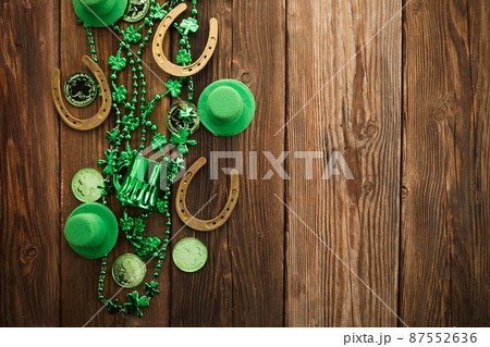 St Patricks Day border of shamrocks beads and coins over a rustic wood background St Patricks Day border of shamrocks beads and coins over a rustic wood background 87552636