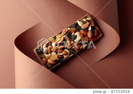 The mix of dried fruits and berries on a brown background. The mix of dried fruits and berries on a brown background. 87553059