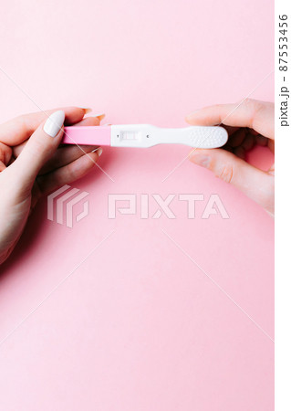 Pregnancy test couple. Positive woman pregnant test in hands with pink silk ribbon on pink background. New life and new family. Motherhood, pregnancy, birth control concept. Pregnancy test couple. Positive woman pregnant test in hands with pink silk ribbon on pink background. New life and new family. Motherhood, pregnancy, birth control concept. 87553456