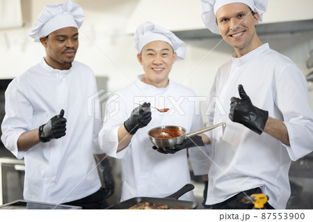 Portrait of three chef cooks with different ethnicities in kitchen Portrait of three chef cooks with different ethnicities in kitchen 87553900