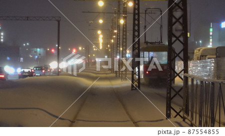 Winter night with a tram going into the distance 87554855