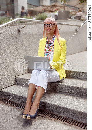 Inspired woman on stair steps using laptop Inspired woman on stair steps using laptop 87556001