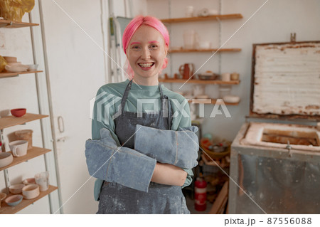Young lady artisan ready for work in ceramic workshop Young lady artisan ready for work in ceramic workshop 87556088