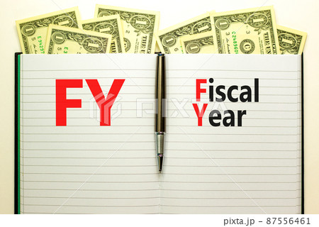 FY Fiscal year symbol. Concept words FY Fiscal year on white note. Metallic pen. Dollar bills. Beautiful white background. Business and FY fiscal year concept. 87556461