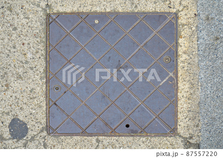 Metal square manhole cover on the floor, fixed on concrete Metal square manhole cover on the floor, fixed on concrete 87557220