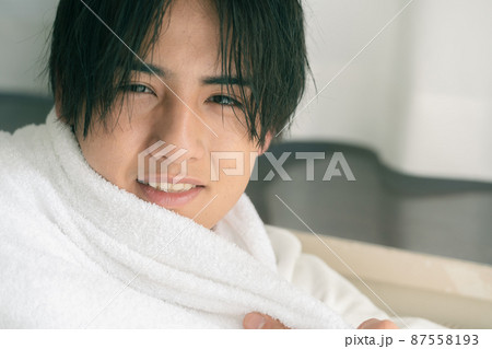 濡れた髪をタオルで乾かす若い男性 濡れた髪をタオルで乾かす若い男性 87558193