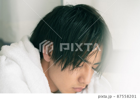 濡れた髪をタオルで乾かす若い男性 濡れた髪をタオルで乾かす若い男性 87558201