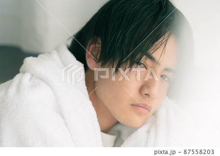 濡れた髪をタオルで乾かす若い男性 87558203